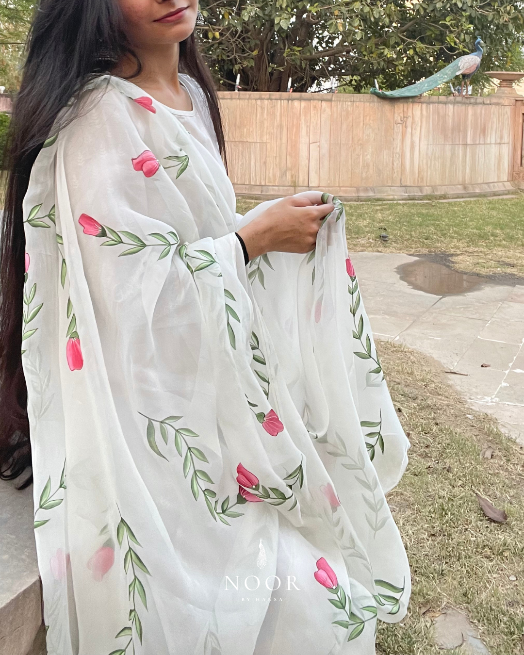 hand painted ivory 'jaituni' odhani in pure organza silk fabric with hand-painted motifs of leaves & pink tulips spread all over, embellished with studded stones. light and flowy, this makes for a perfect summer essential