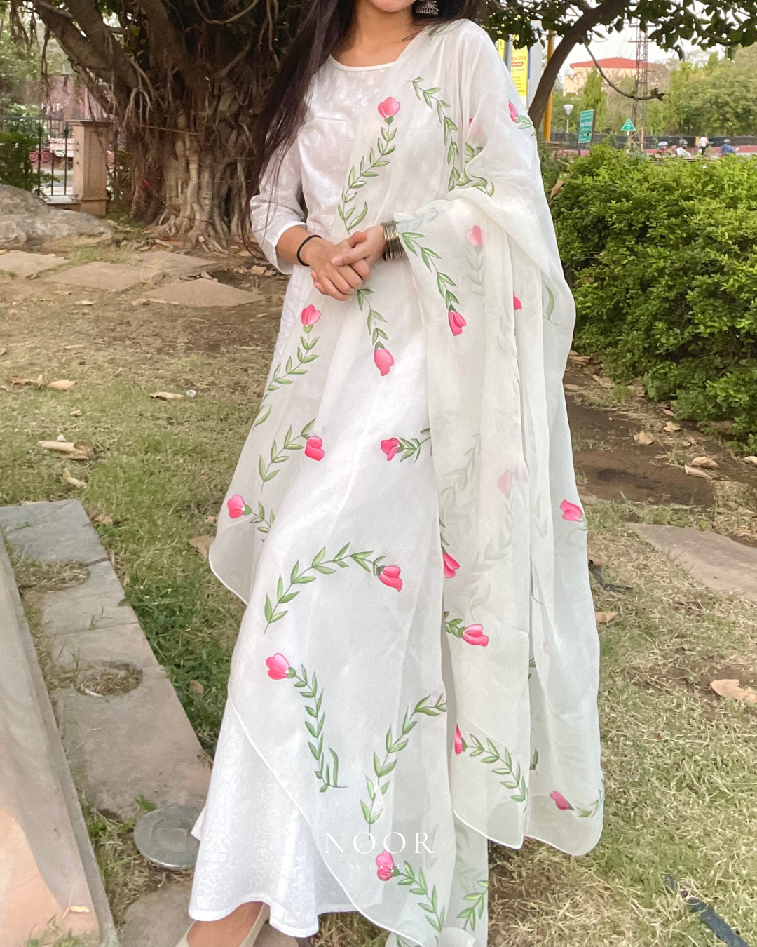 hand painted ivory 'jaituni' odhani in pure organza silk fabric with hand-painted motifs of leaves & pink tulips spread all over, embellished with studded stones. light and flowy, this makes for a perfect summer essential